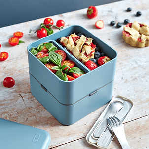Une boite de repas réutilisable posée sur une table avec des couverts