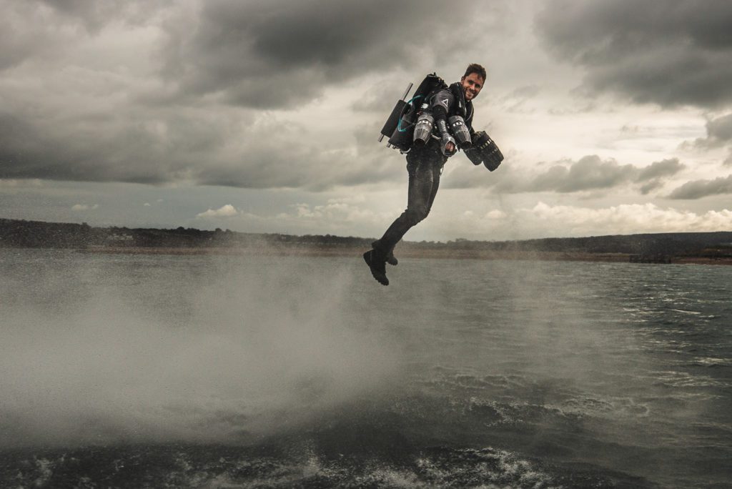Un homme volant au dessus de la mer avec un jetpack dans le dos